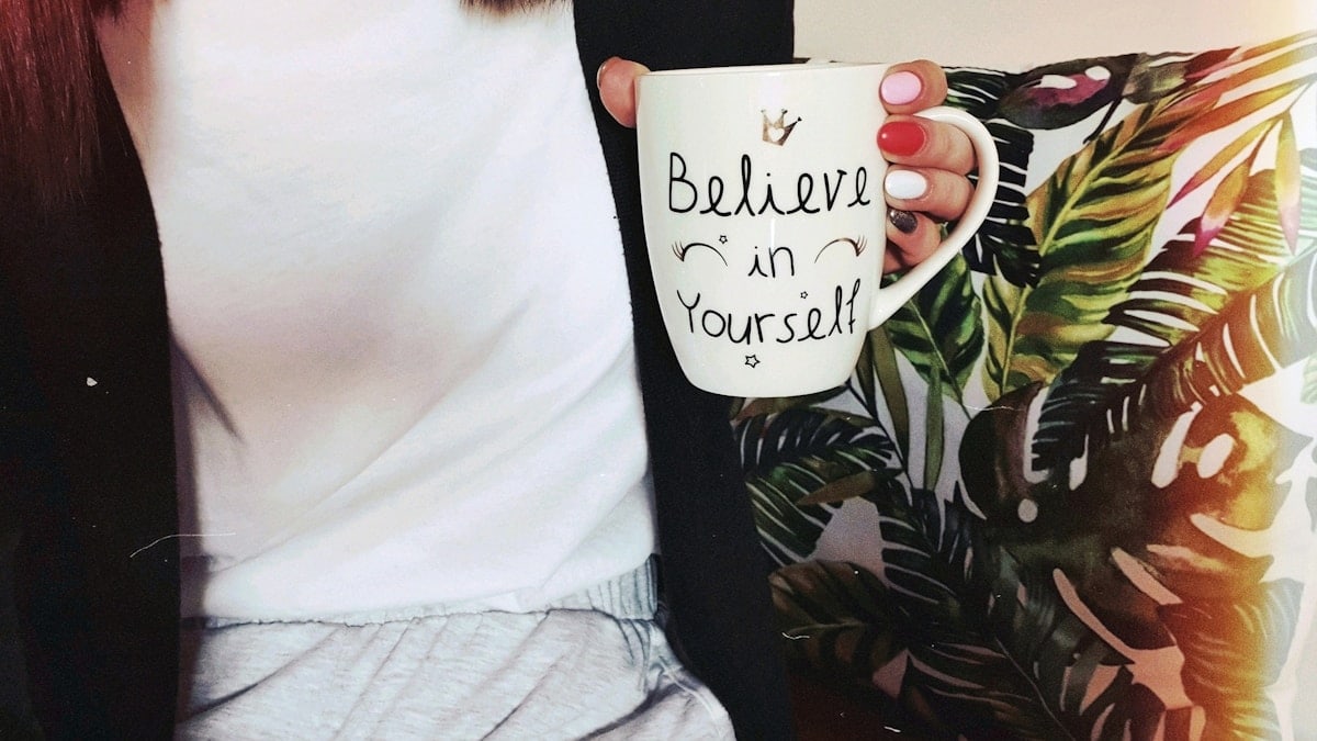 woman wearing black cardigan holding mug